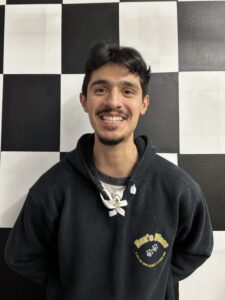 Luis in front of a checkerboard wall