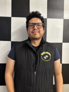 Rodolfo Serna standing in front of a checkerboard wall